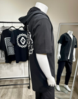 Mannequin wearing a black hoodie with white patterns in a store setting.