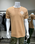 Mannequin wearing a beige t-shirt with a logo in a store setting