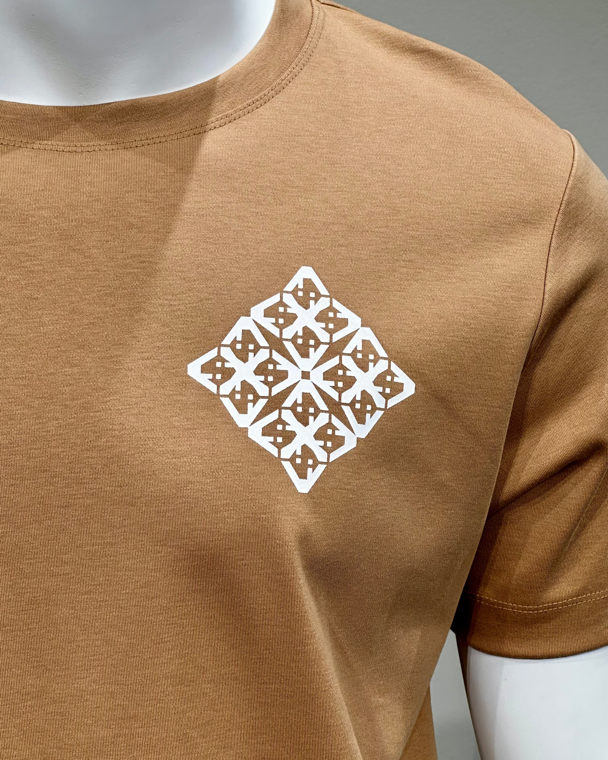 Brown t-shirt with a white geometric pattern on a mannequin against a gray background