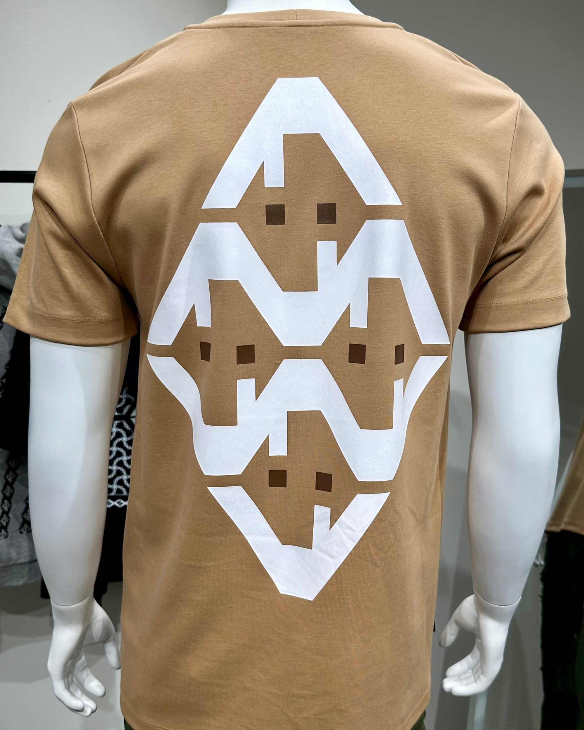 Brown t-shirt with white geometric pattern on a mannequin